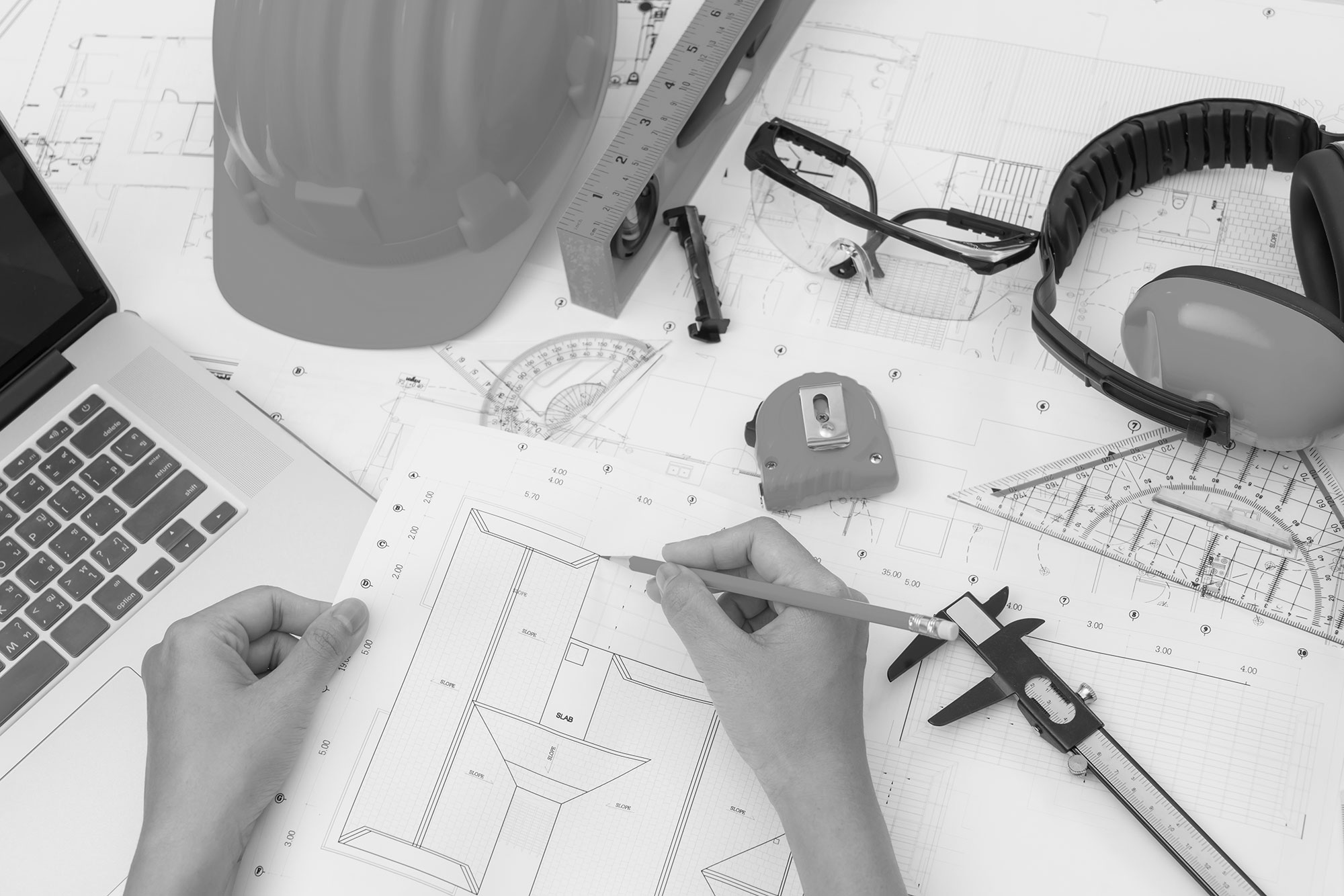 Consultoría técnica Mano sobre planes construccion casco amarillo herramienta dibujo bn